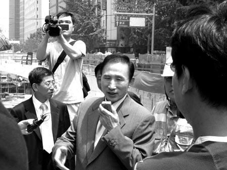 李明博在清溪川接受記者采訪。