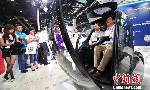   圖為美國通用公司展出了造型奇異、轉(zhuǎn)向靈便、前開門的EN-V妙(圖)和EN-V笑兩款微型鋰電電動車。中新社發(fā) 鄒憲 攝