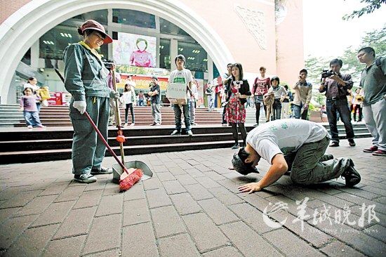 康毅跪在環衛工人面前，作出膜拜狀