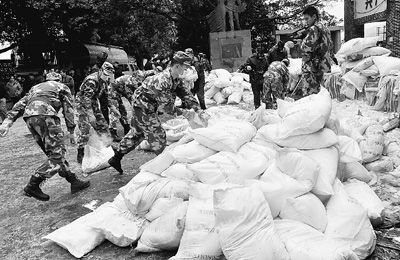 1月29日，在廣西柳州市柳城縣糯米灘水電站，武警戰士和消防官兵在搬運絮凝劑。新華社記者 陸波岸攝