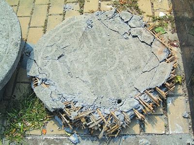 破損的窨井蓋露出里面的竹子。  肖雷 攝
