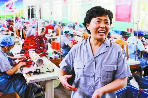邵均克向中國高校傳媒聯盟的大學生記者介紹華苑公司針織二廠的生產情況