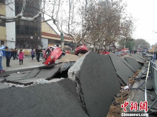 在距離青島爆燃事故爆炸中心現(xiàn)場1公里外的青島市黃島區(qū)齋堂島街，受爆炸沖擊的街道露出了20多厘米厚的混凝土路面，似揭開的魚鱗，路邊躺著十余輛側(cè)翻的汽車。 黃品璇 攝