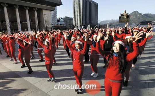 28日下午，在首爾光化門廣場上，首爾綜合藝術學校的350名學生身穿紅色內衣正在跳舞。他們伴隨2014年仁川亞運會主題歌跳1個小時的舞蹈，呼吁將仁川亞運會打造成“低碳環保大會”。（韓國《朝鮮日報》網站截圖） 