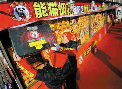 昨日上午，工體東路的朝陽區熊貓煙花第二直營店，工作人員將即將銷售的煙花擺上貨架。當日，馬年煙花爆竹正式開始銷售。